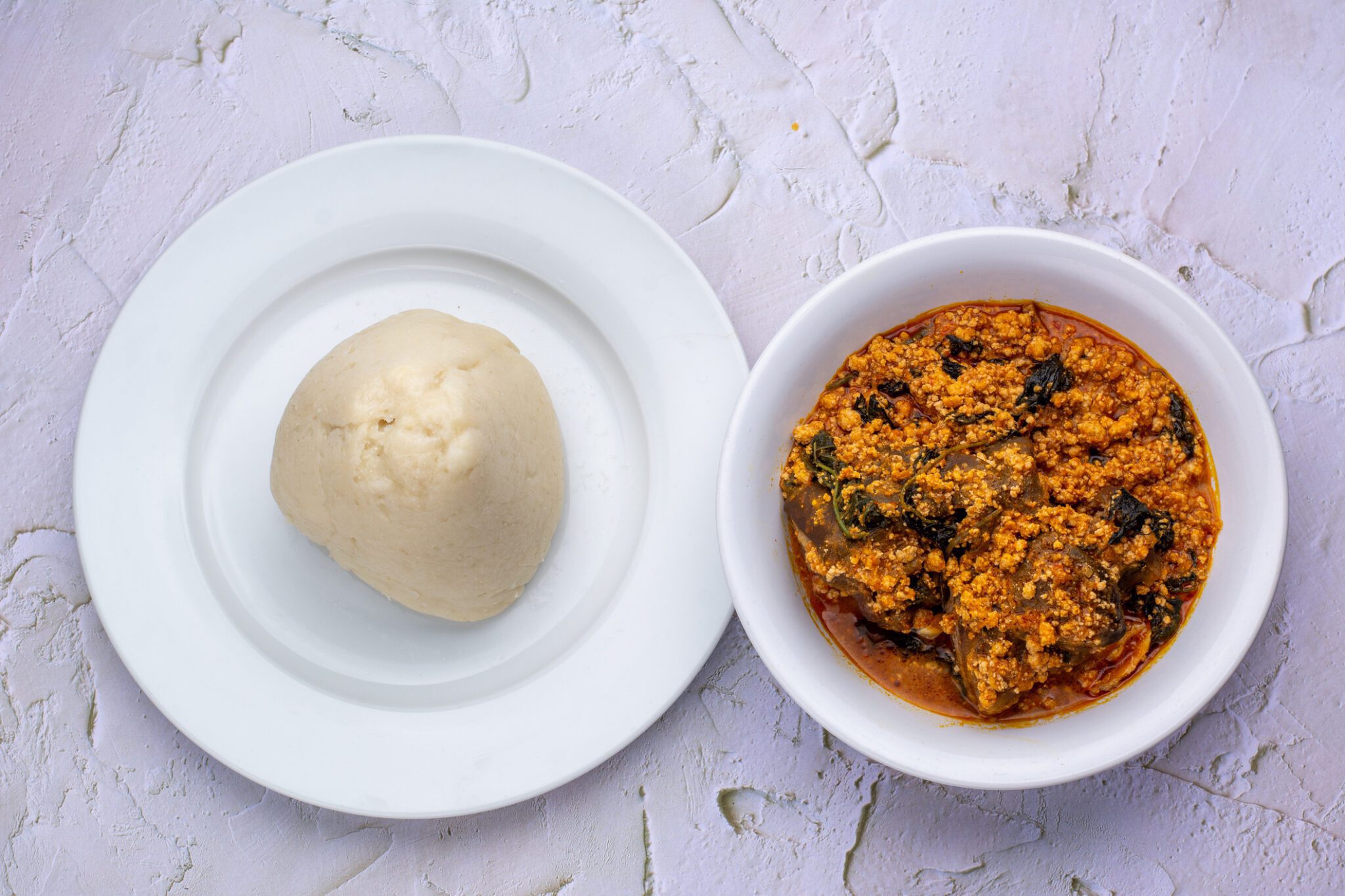 Pounded yam and egusi soup on plates.