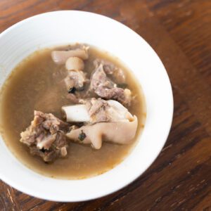 Hearty meat soup in a white bowl.